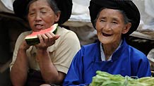 Two old women attend a fair in Xiaohe Town of Qiaojia County, southwest China's Yunnan Province, July 15, 2010.