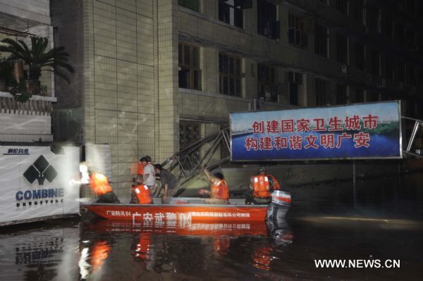 Armed police are searching for people trapped by flood in Guang'an City, southwest China's Sichuan Province, July 19, 2010. 