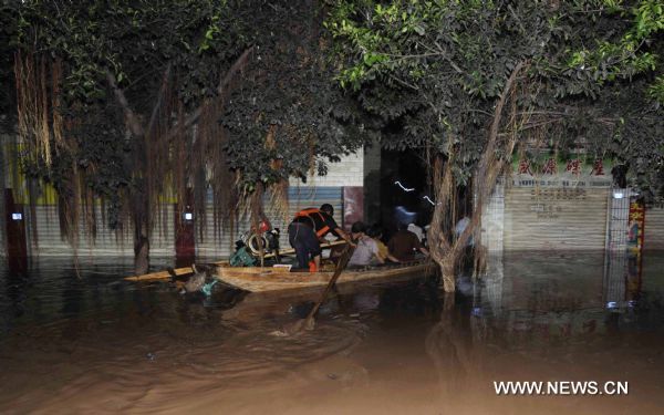  A man transfer his fellows trapped by flood in Guang'an City, southwest China's Sichuan Province, July 19, 2010.