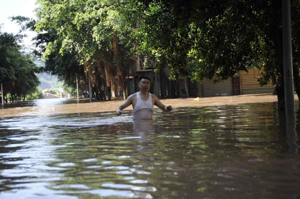 A man waits for help in flood waters in Guang'an, Southwest China's Sichuan province on July 19, 2010