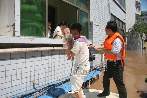 Rescuers evacuate local residents trapped by flood waters in Guang'an, Southwest China's Sichuan Province on July 19, 2010.