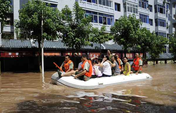 Soldiers transfer people trapped by flood water on a rubber boat in Guang'an, Southwest China's Sichuan Province on July 19, 2010. 