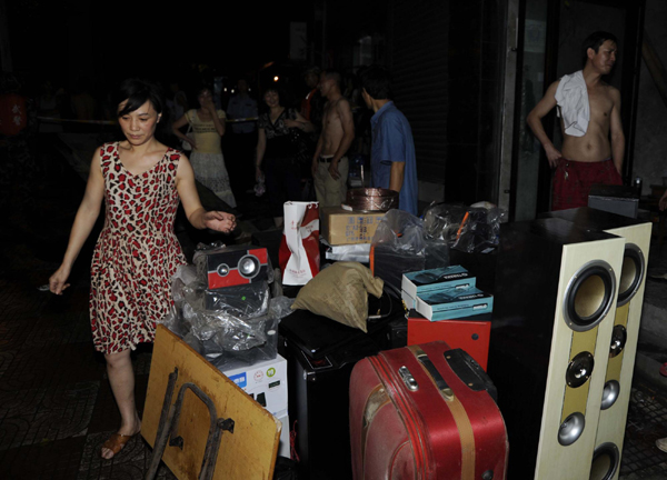 People gather their belongings before leaving their flooded houses in Guang'an, Southwest China's Sichuan Province on July 19, 2010.