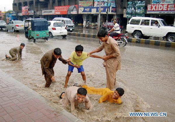 Children have fun in the waterlogged street in northwest Pakistan&apos;s Peshawar on July 22, 2010. At least 25 people were killed due to heavy rainfall brought by the monsoon in Pakistan.