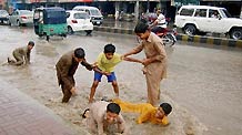 Children have fun in the waterlogged street in northwest Pakistan's Peshawar on July 22, 2010. At least 25 people were killed due to heavy rainfall brought by the monsoon in Pakistan.