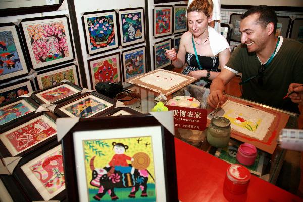 Foreign visitors learn to draw rural paintings in Fengjing Township in east China&apos;s Shanghai, July 22, 2010. 
