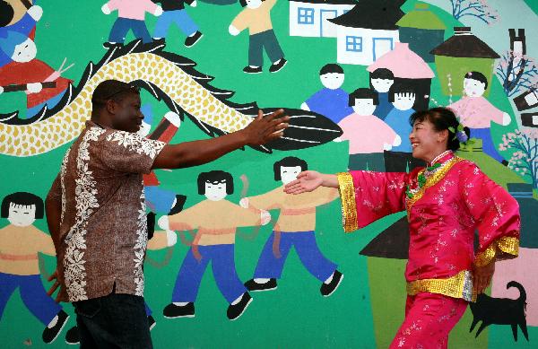 A foreign visitor learns local dance from a villager in Fengjing Township in east China&apos;s Shanghai, July 22, 2010. 