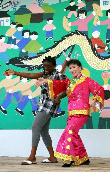 A foreign visitor learns local dance from a villager in Fengjing Township in east China&apos;s Shanghai, July 22, 2010.