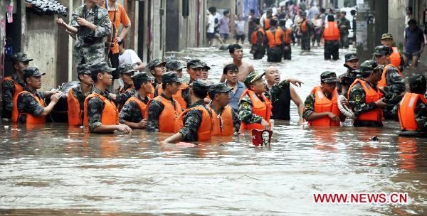 The file photo taken on July 17, 2010 shows military personnel search for residents trapped in flood in Guangshui, a city of central China's Hubei Province. (Xinhua Photo)