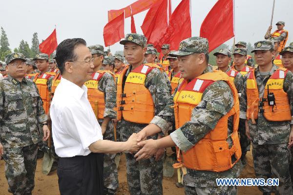 Chinese Premier Wen Jiabao (L, front) visits soldiers at a stone storing site at Huaihe River dike, east China's Anhui Province, July 24, 2010. Wen Jiabao Saturday visited Anhui Province to inspect the flood control operations along the Huaihe River.