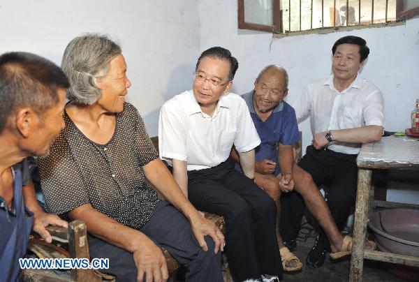 Chinese Premier Wen Jiabao (C) talks with local residents in Hexie Village of Wangjiaba Township, east China's Anhui Province, July 24, 2010.