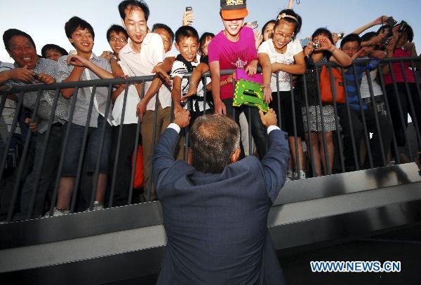 Former British Prime Minister Tony Blair shakes hands with tourists at the World Expo Park in east China's Shanghai on July 27, 2010. 