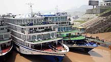 Cruise ships anchor at the Zigui port for passenger transfer in Yichang, central China's Hubei Province, July 28, 2010.