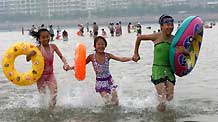 Children enjoy themselves in the sea in Weihai, east China's Shandong Province, July 29, 2010. Hot weather hit more than 15 provinces and municipalities in China Thursday.