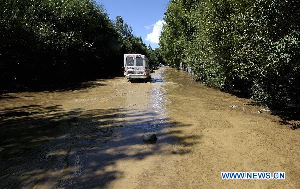 Vehicles move slowly on a flood ravaged road linking Lhasa and Quxu County in Tibet Autonomous Region on July 30, 2010. Five kilometers of the road was covered by flood water caused by heavy rains, which caused a traffic jam. The road is also the only way for people to get to Gonggar airport in Lhasa. 