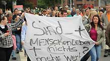 People hold a demonstration outside the city hall in Duisburg, western Germany, on July 29, 2010, to call for the resignation of mayor Adolf Sauerland over the Love Parade disaster, in which 21 people died and more than 500 were injured in a stampede on July 24.