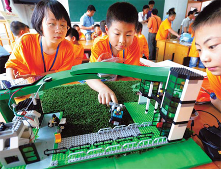 Participants fix a low-carbon school gate model during a creative competition in Taizhou, east China's Jiangsu Province, on Wednesday.