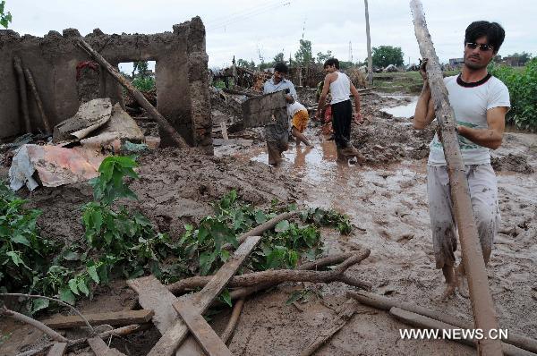 People clear debris as their houses were flooded following heavy monsoon rains in northwest Pakistan&apos;s Peshawar, on July 30, 2010. At least 420 people were killed in the flood-hit Khyber Pakhtunkhwa province in northwest Pakistan, said the Pakistani interior minister Rehman Malik on Friday.