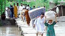 People migrate with their belongings as their houses were flooded following heavy monsoon rains in northwest Pakistan's Peshawar, on July 30, 2010. At least 420 people were killed in the flood-hit Khyber Pakhtunkhwa province in northwest Pakistan, said the Pakistani interior minister Rehman Malik on Friday.
