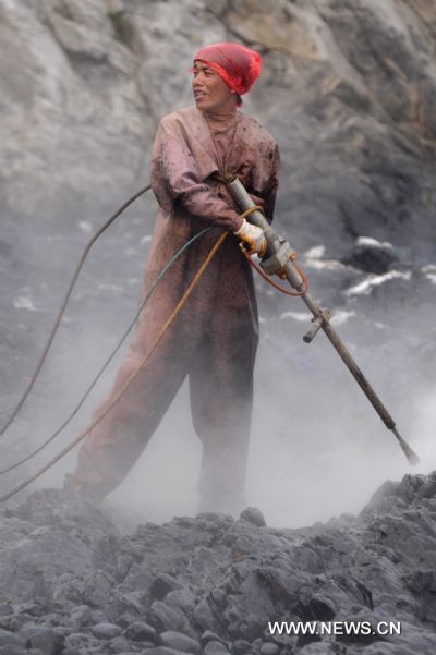 A worker cleans the reefs at Xieziwan bay in Dalian, northeast China&apos;s Liaoning Province, July 30, 2010. Industrial cleaners and gas welding blowpipes were devoted to clean the reefs after the oil pipe explosion at Dalian Xingang Harbor. (Xinhua/Ma Yidong) (ly) 