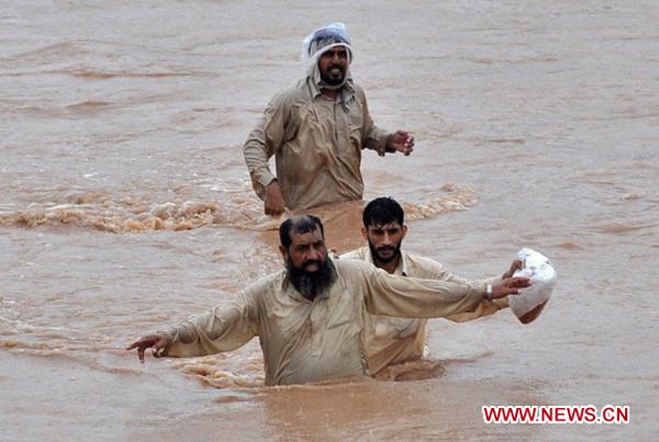 People walk through the waterlogged street in northwest Pakistan&apos;s Pabbi on Aug. 1, 2010. 