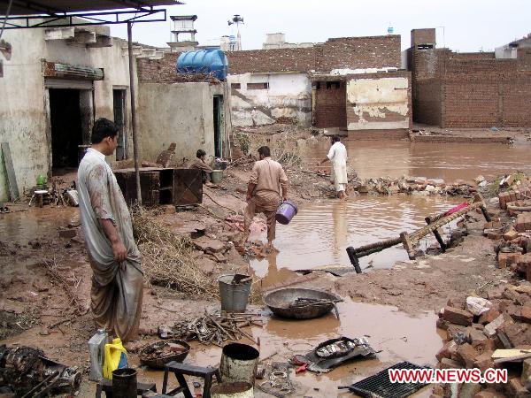 People clear debris as their houses were flooded following heavy monsoon rains in northwest Pakistan&apos;s Nasir-Bagh on Aug. 1, 2010.