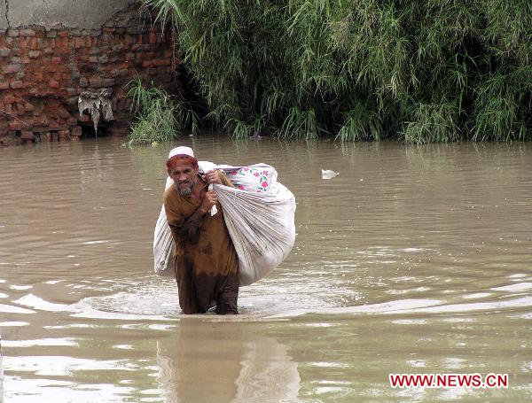 A Pakistani man walks through the waterlogged street in northwest Pakistan&apos;s Nasir-Bagh on Aug. 1, 2010. 