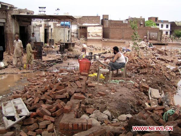 People clear debris as their houses were flooded following heavy monsoon rains in northwest Pakistan&apos;s Nasir-Bagh on Aug. 1, 2010.