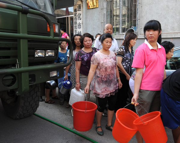Residents line up for drinking water in Tonghua, Jilin Province August 2. Torrential rain has damaged water pipelines in the city, leaving 330,000 people without tap water.