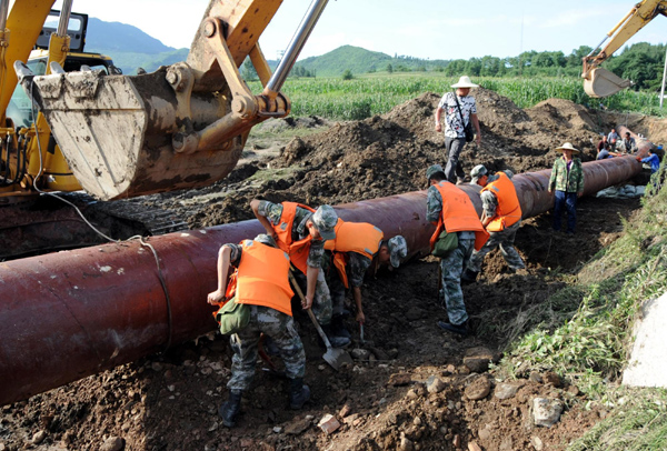 Soldiers race against time to repair a water pipeline which was damaged by torrential rain in Tonghua, an industrial city in Northeast China's Jilin province August 2. [Xinhua]