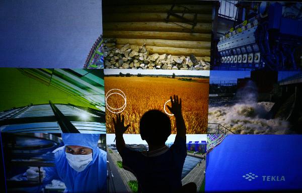 Photo taken on Aug. 1, 2010 shows a boy touching a LED screen in the Finland Pavilion at the 2010 World Expo in Shanghai, east China.