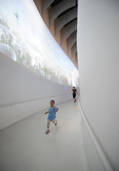 Photo taken on Aug. 1, 2010 shows a mother chasing her son in the Finland Pavilion at the 2010 World Expo in Shanghai, east China. 