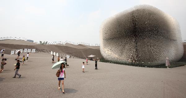 Tourists walk outside the UK Pavilion in the World Expo Park in Shanghai, east China, Aug. 3, 2010. 