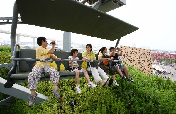 Tourists look at the scenery on a cable car in the World Expo Park in Shanghai, east China, Aug. 3, 2010. 