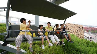 Tourists look at the scenery on a cable car in the World Expo Park in Shanghai, east China, Aug. 3, 2010.