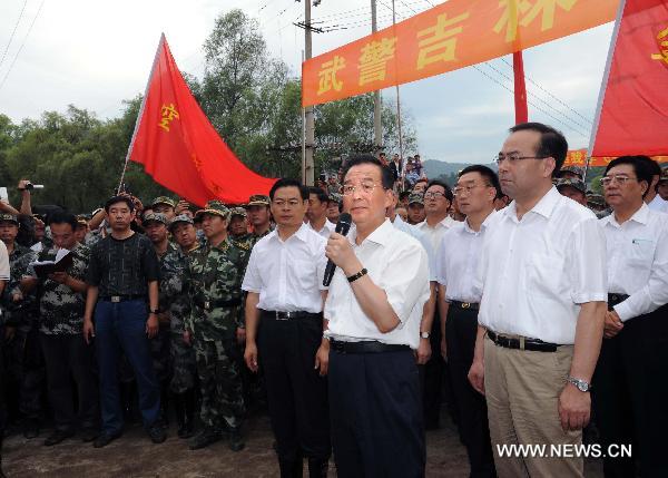 Chinese Premier Wen Jiabao (2nd R, front), who is also a member of the Standing Committee of the Political Bureau of the Communist Party of China Central Committee, addresses soldiers and local people in the flood-hit area in Yongji County of Jilin City, northeast China's Jilin Province on Aug. 3, 2010.