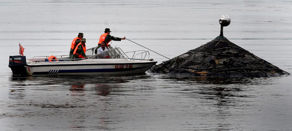 Local soldiers block floating objects from the upper reaches of the Yalu River in Dandong, a border city of northeast China's Liaoning Province, August 4, 2010. 