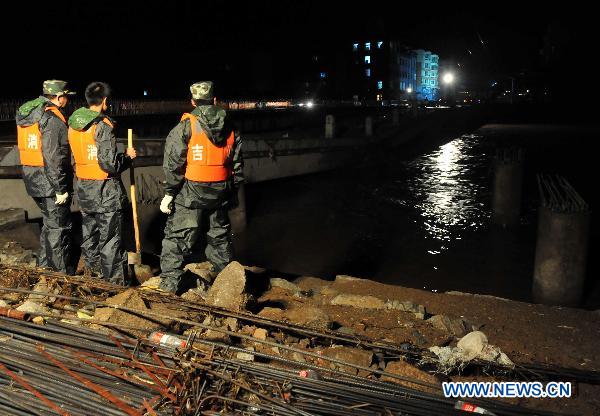 Rescuers inspects at a dike of a river in Yongji County, northeast China's Jilin Province, Aug. 5, 2010.