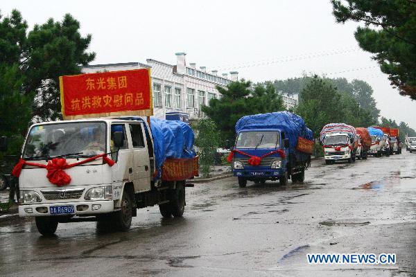 Trucks carrying relief materials arrives at the flood-ravaged area in Nong'an County, northeast China's Jilin Province, Aug. 5, 2010.