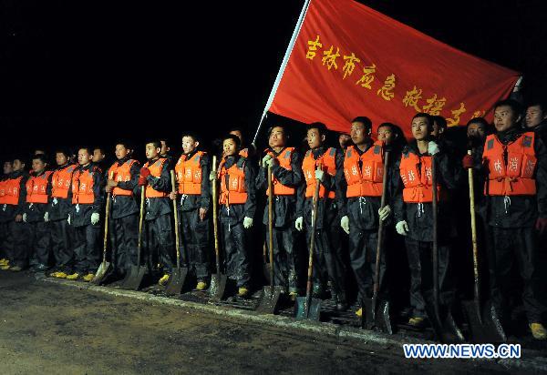 Rescuers gather before heading out to protect the river dike in Yongji County, northeast China's Jilin Province, Aug. 5, 2010.