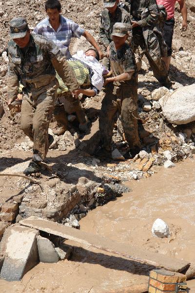 Rescuers carry a victim in the landslide-hit region in Zhouqu County, Gannan Tibetan Autonomous Prefecture in northwest China's Gansu Province, Aug. 8, 2010. 