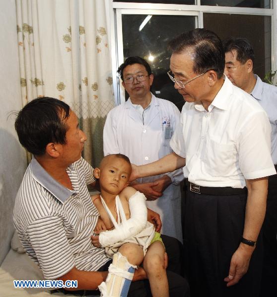 Chinese Premier Wen Jiabao(R front) visits injured persons who got hurt during the landslides at a hospital in Zhouqu County, Gannan Tibetan Autonomous Prefecture in northwest China's Gansu Province, Aug. 8, 2010.