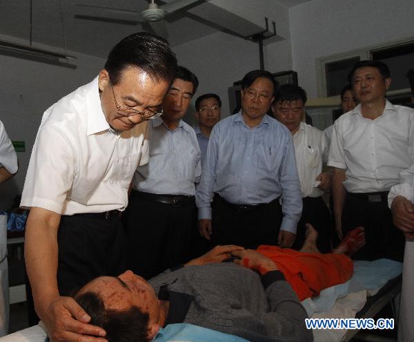 Chinese Premier Wen Jiabao(L front) visits an injured person who got hurt during the landslides at a hospital in Zhouqu County, Gannan Tibetan Autonomous Prefecture in northwest China&apos;s Gansu Province, Aug. 8, 2010.