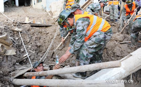 Soldiers provide nutritional supplies for a survivor in landslides-hit Zhouqu County, Gannan Tibetan Autonomous Prefecture in northwest China's Gansu Province, Aug. 8, 2010. 