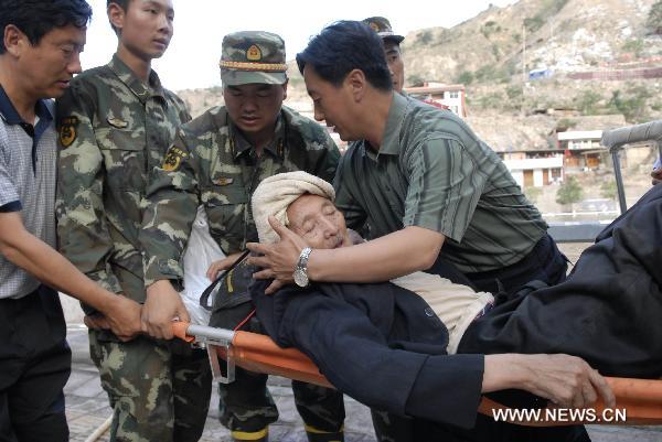 Rescuers carry a 78-year-old survivor in landslide-hit Zhouqu County, Gannan Tibetan Autonomous Prefecture in northwest China's Gansu Province, Aug. 8, 2010. 