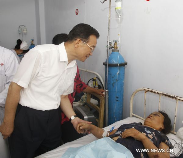 Chinese Premier Wen Jiabao (L Front) visits a woman injured in the landslides, at a hopital in Zhouqu County, Gannan Tibetan Autonomous Prefecture in northwest China&apos;s Gansu Province, Aug. 9, 2010. 