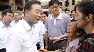 Chinese Premier Wen Jiabao (L Front) visits local residents who lost their relatives in the landslides in Zhouqu County, Gannan Tibetan Autonomous Prefecture in northwest China's Gansu Province, Aug 9, 2010.