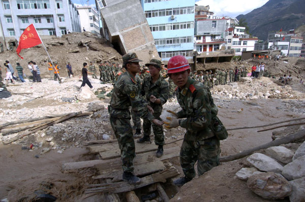 Rescue workers search for survivors in the debris after a landslide in Zhouqu county, Gannan Tibetan autonomous prefecture in Northwest China&apos;s Gansu province Sunday. More than 680 residents had been rescued by Sunday noon. [Xinhua]