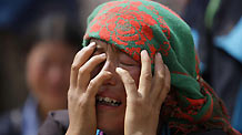 A woman cries before the debries of her house in the landslide-hit Zhouqu County of Gannan Tibetan Autonomous Prefecture, Gansu Province August 9, 2010.