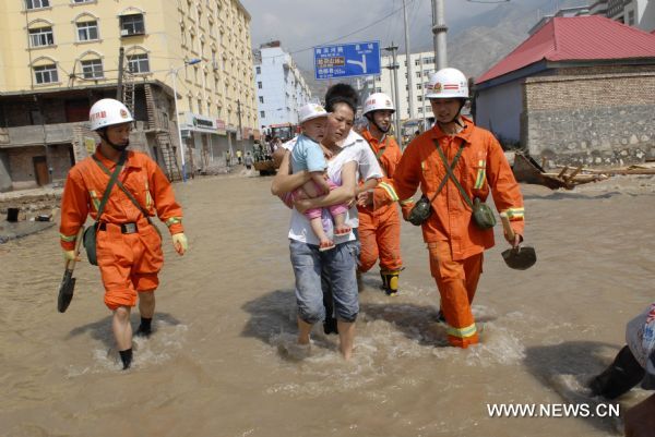 Firefighters evacuate residents to a safe place in landslides-hit Zhouqu County, Gannan Tibetan Autonomous Prefecture in northwest China&apos;s Gansu Province, Aug. 9, 2010. Recuers have saved 77 people from rain-triggered landslides in Zhouqu County as of 11:00 AM local time (0300 GMT) Aug. 9.